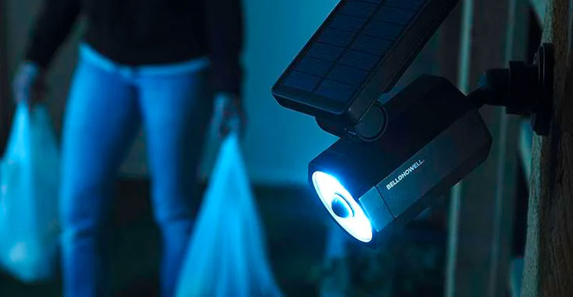Person walking up the side of a house and a lit security light