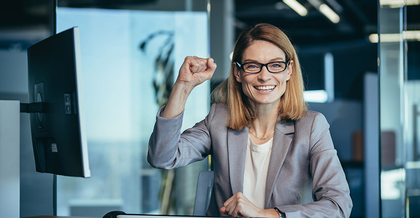Woman wearing a suit with her fist up in celebration
