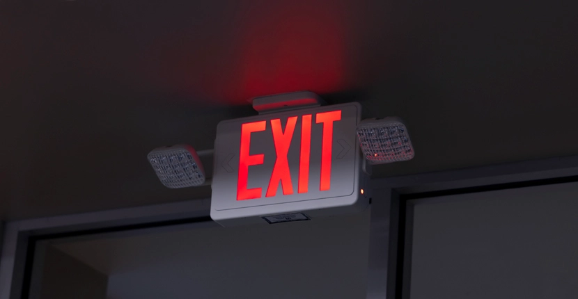 Exit sign on the ceiling in a dark hallways