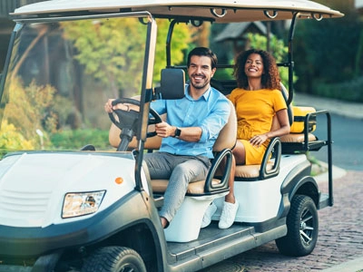 2 people in a golf cart on a path