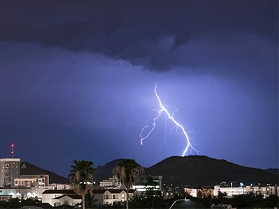 City at night with a lightning strike in the distance 