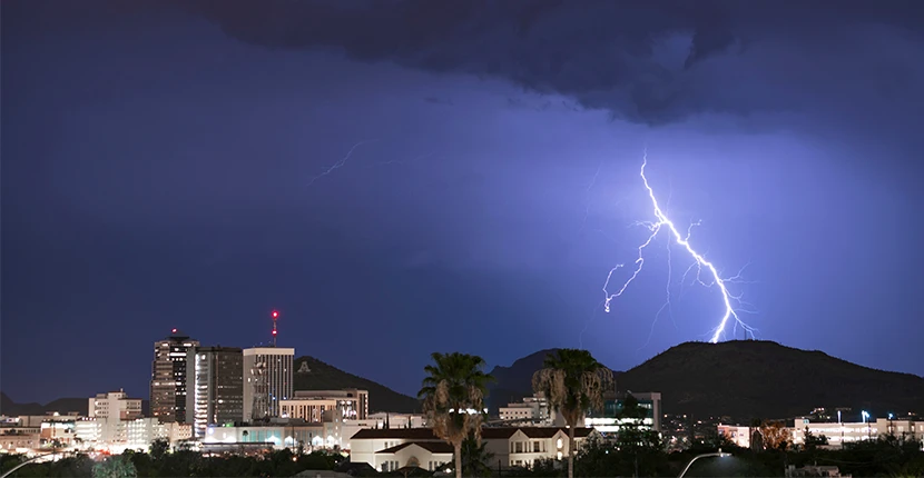 City at night with a lightning strike in the distance 
