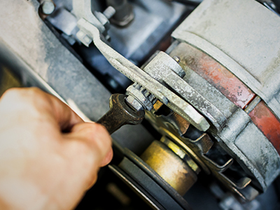 Using a wrench to remove a starter