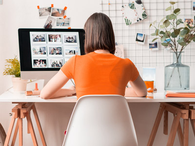 Woman in orange shirt working at an at-home office