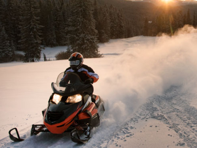 riding a snowmobile in an open area